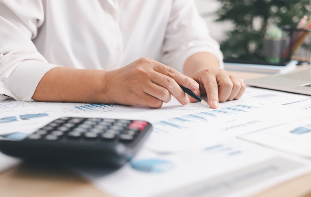 Professional accountant using a calculator to manage business finances on Odoo.
